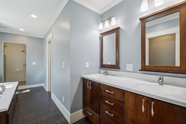 full bathroom with double vanity, a sink, tiled shower, and baseboards