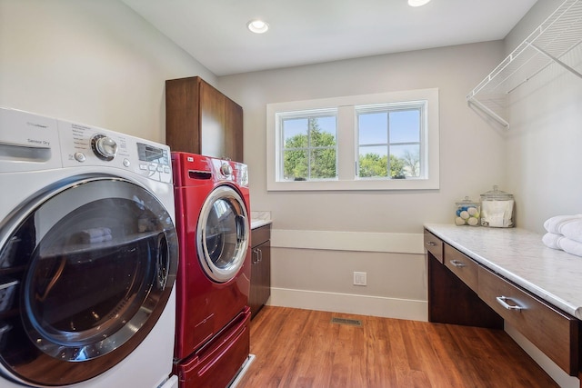 laundry room featuring recessed lighting, cabinet space, washer and clothes dryer, visible vents, and wood finished floors