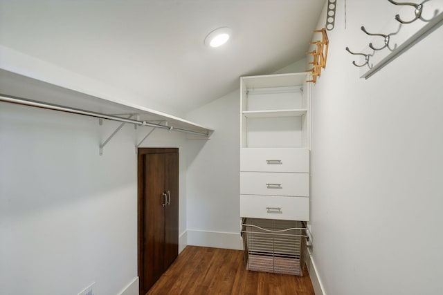 spacious closet featuring dark wood-style flooring and lofted ceiling