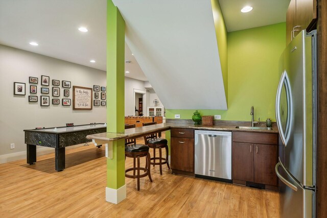 bar featuring recessed lighting, a sink, appliances with stainless steel finishes, and light wood-style floors