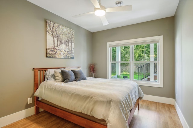 bedroom with wood finished floors, a ceiling fan, and baseboards