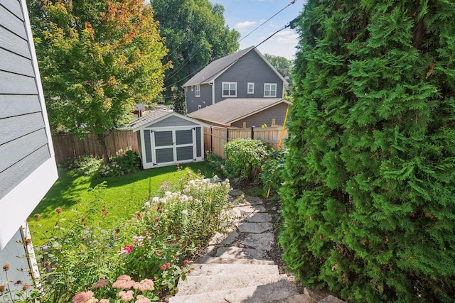 view of yard with an outdoor structure, a storage shed, and a fenced backyard
