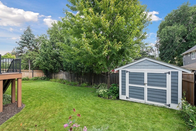view of yard featuring a storage shed, a deck, an outdoor structure, and a fenced backyard