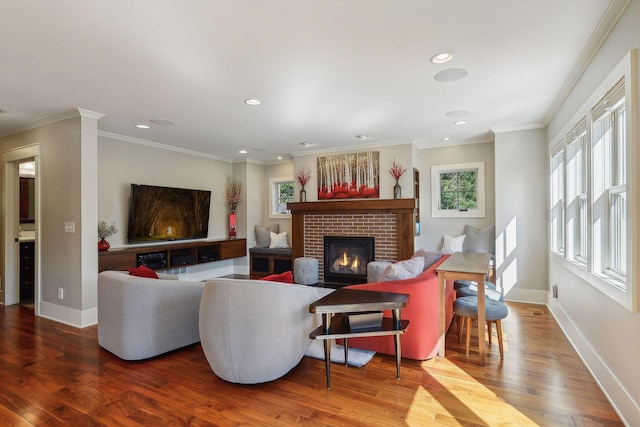 living area with baseboards, recessed lighting, ornamental molding, a fireplace, and wood finished floors