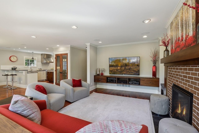 living area with crown molding, a brick fireplace, baseboards, and dark wood-type flooring