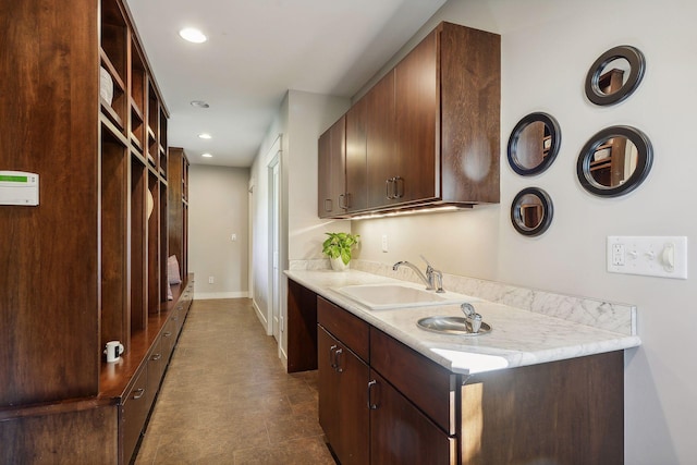 interior space featuring recessed lighting, baseboards, and a sink