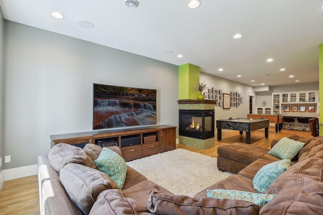living area with visible vents, a multi sided fireplace, wood finished floors, and recessed lighting