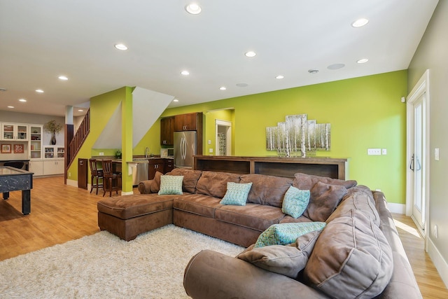 living room featuring baseboards, recessed lighting, stairway, and light wood finished floors