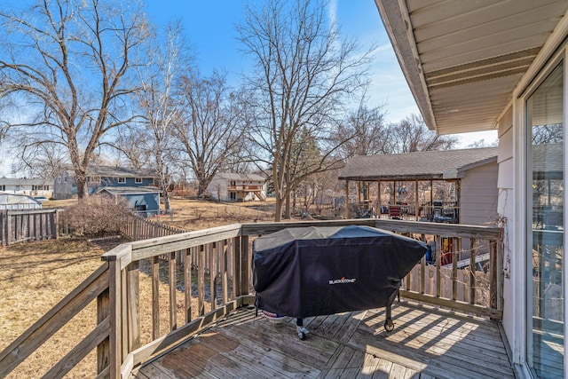 wooden terrace featuring a residential view, a grill, and fence