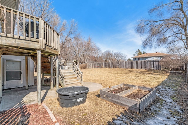 view of yard featuring stairway, fence, an outdoor fire pit, a vegetable garden, and a deck