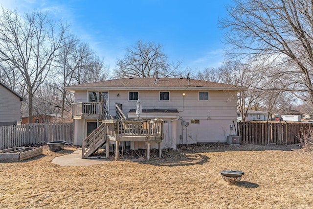 rear view of property featuring fence, a garden, a yard, stairs, and a deck