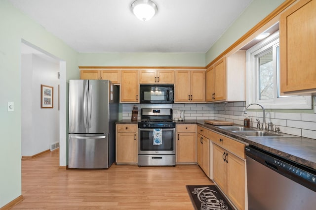 kitchen with a sink, visible vents, tasteful backsplash, and appliances with stainless steel finishes