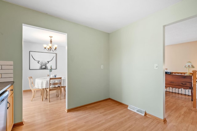 dining room featuring a notable chandelier, visible vents, and light wood-style floors