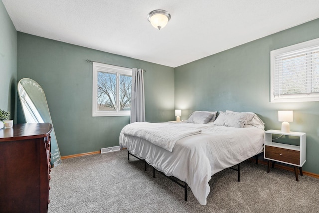 carpeted bedroom with visible vents and baseboards