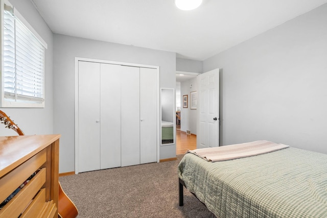 bedroom with light colored carpet and a closet