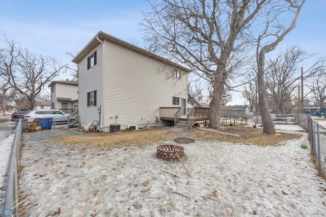 rear view of house featuring fence, a fire pit, a deck, and cooling unit