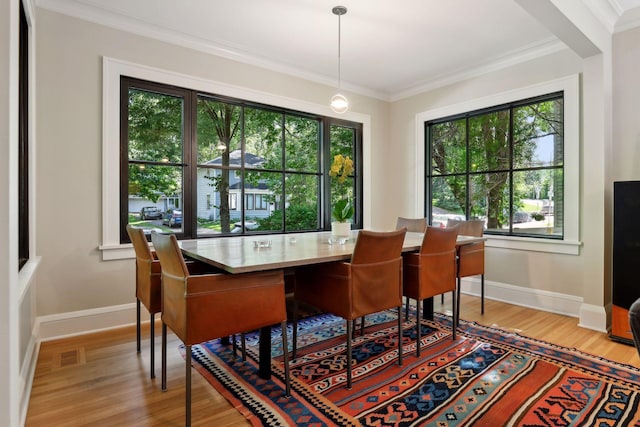 dining room featuring crown molding, visible vents, baseboards, and light wood finished floors