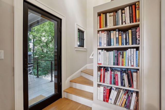 entryway featuring a wealth of natural light, stairs, and wood finished floors