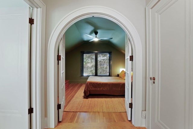 bedroom featuring light wood-type flooring, ceiling fan, and vaulted ceiling