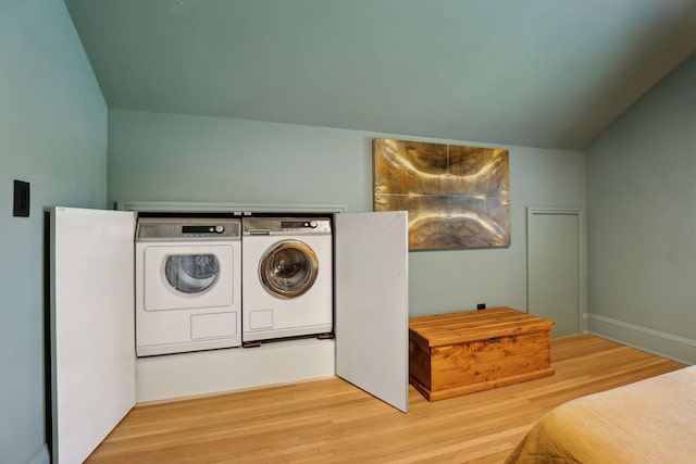 clothes washing area featuring wood finished floors, laundry area, and washing machine and clothes dryer