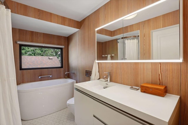 full bathroom featuring tile patterned flooring, wooden walls, a washtub, toilet, and vanity