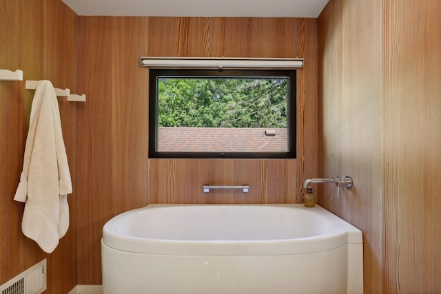 bathroom featuring a bath and visible vents