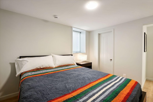 bedroom with wood finished floors and baseboards