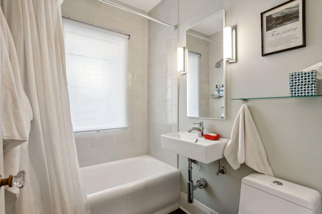 bathroom with a sink, toilet, and shower / tub combo