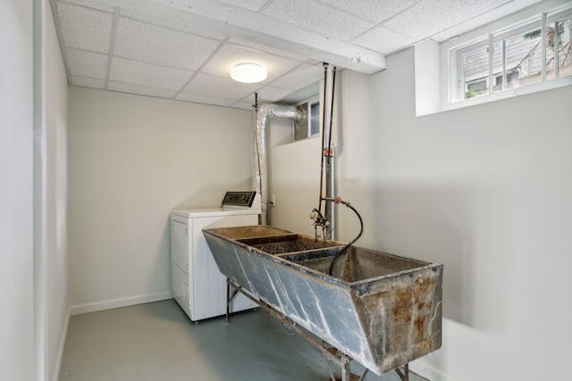 laundry room with a sink, baseboards, and washer / dryer