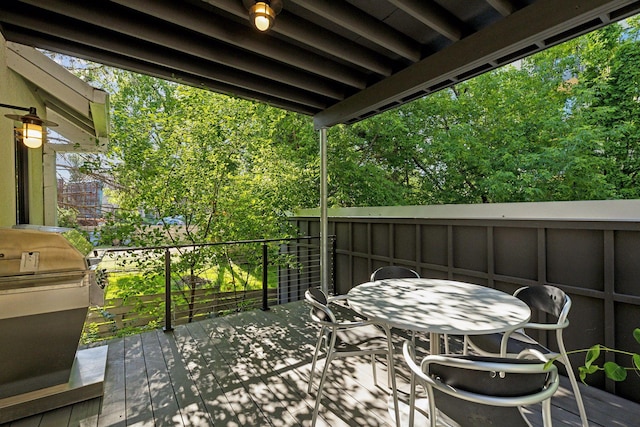 wooden terrace featuring outdoor dining space and a grill