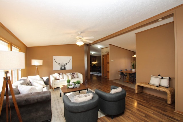 living room with lofted ceiling, ceiling fan, ornamental molding, wood finished floors, and a textured ceiling