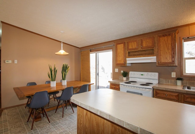 kitchen with electric stove, ornamental molding, brown cabinets, light countertops, and under cabinet range hood