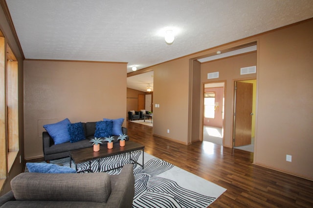 living area featuring a textured ceiling, wood finished floors, and visible vents