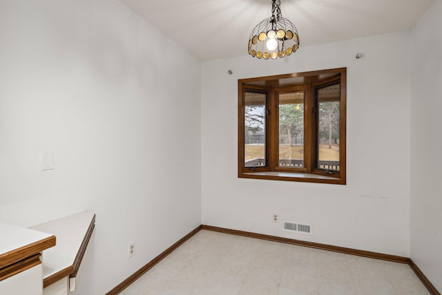 unfurnished dining area with baseboards and visible vents