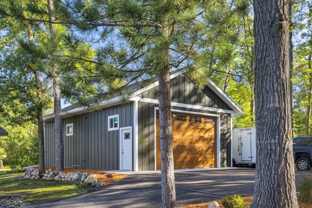 view of outdoor structure with driveway and an outbuilding