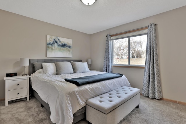 bedroom featuring light carpet, a textured ceiling, and baseboards