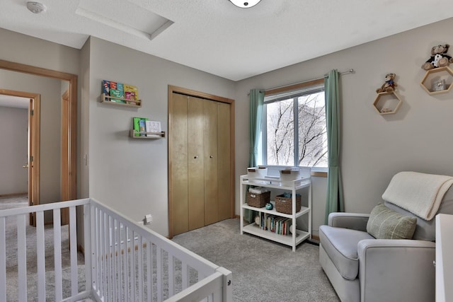 bedroom with carpet floors, attic access, a closet, and a textured ceiling