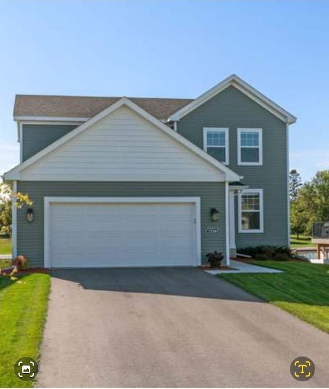 traditional home featuring an attached garage, driveway, and a front yard