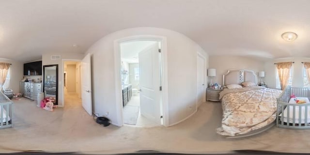 bedroom featuring visible vents, connected bathroom, carpet flooring, and vaulted ceiling