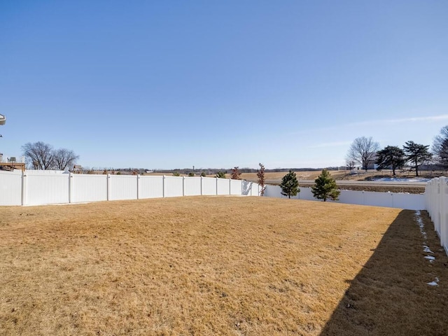 view of yard featuring a water view and a fenced backyard