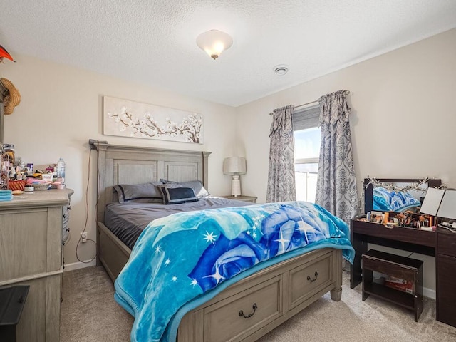 bedroom with light colored carpet and a textured ceiling