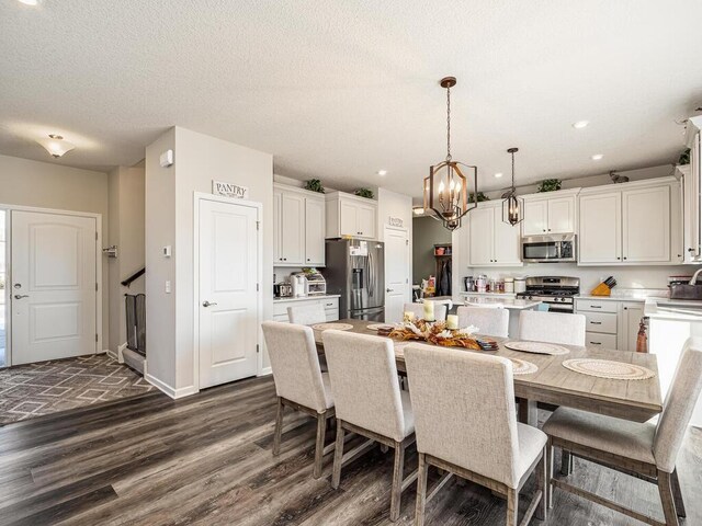 dining room featuring baseboards, dark wood finished floors, recessed lighting, an inviting chandelier, and a textured ceiling