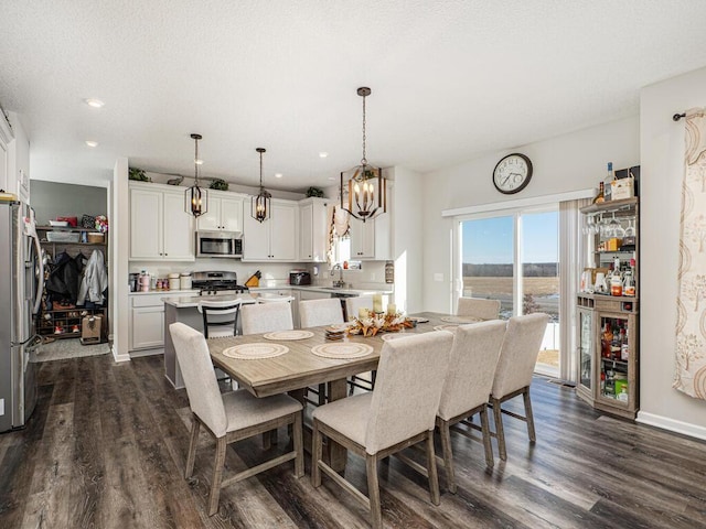 dining area featuring dark wood finished floors, recessed lighting, baseboards, and a textured ceiling