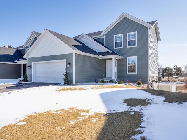 traditional-style home with central air condition unit and an attached garage