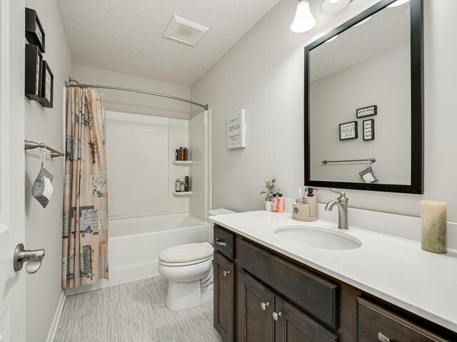 bathroom featuring shower / tub combo, a textured ceiling, vanity, and toilet