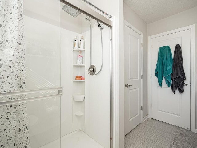 bathroom featuring a textured ceiling and a stall shower