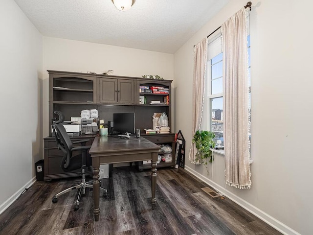 office featuring visible vents, baseboards, a textured ceiling, and dark wood-style floors