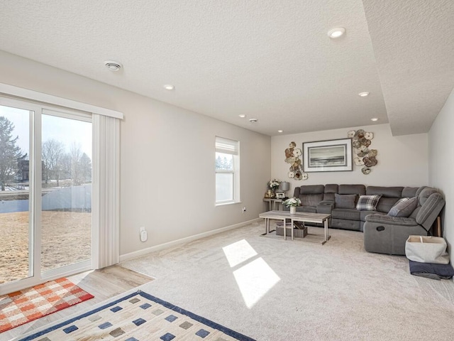 living area with recessed lighting, baseboards, a textured ceiling, and carpet flooring