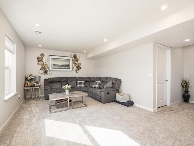 living area featuring recessed lighting, baseboards, and light carpet