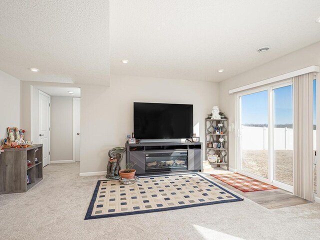 carpeted living room featuring recessed lighting, baseboards, and a textured ceiling